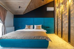 布克维Greitser Elit Chalet的一间卧室配有蓝色床头板和一张床