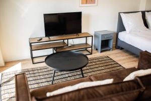 鹿特丹The Hendrick的带沙发、桌子和电视的客厅