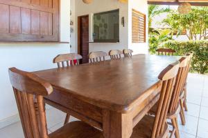 圣米格尔-杜戈斯托苏Pousada Villa Martins的一间带木桌和椅子的用餐室