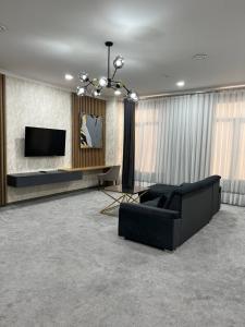 塔什干ART RESIDENCE Hotel的客厅配有黑色沙发和电视