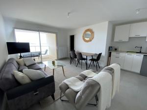 圣布里文莱丝皮恩Appartement Saint-Brevin-les-Pins, 2 pièces, 3 personnes - FR-1-364-140的一间带两张沙发和一张桌子的客厅以及一间厨房