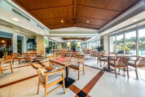 芭东海滩普吉岛-安达曼海滩海景度假酒店 Phuket-Andaman Beach Seaview Hotel的餐厅设有桌椅和窗户。