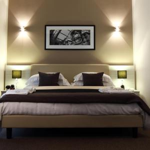 那不勒斯布斯内斯特斯特尔酒店的一间卧室配有一张大床和两盏灯