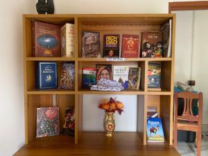 加尔各答Sarkar Villa Homestay的书架上书本和花瓶