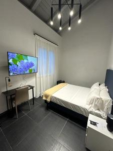 罗马Dazio Exclusive Rooms的卧室配有1张床、1张书桌和1台平面电视。