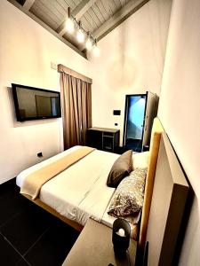 罗马Dazio Exclusive Rooms的一间卧室配有一张床和一台电视。