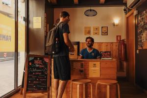 巴塞罗那Onefam Sants的两个男人站在餐厅柜台