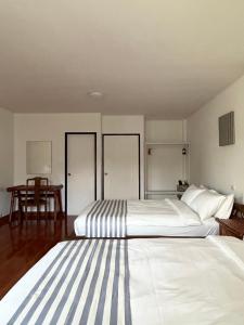 蔻立Nautical Home B&B Khaolak的一间卧室配有两张床和一张桌子