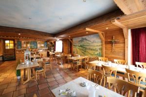 布伦贝格赫斯晨旅馆的一间带桌椅和壁画的餐厅