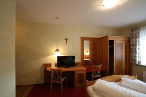 布伦贝格赫斯晨旅馆的一间卧室配有一张床和一张书桌及电视