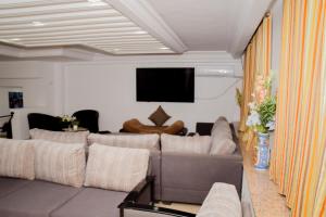乌姆苏克LE GRAND HOTEL的带沙发和平面电视的客厅