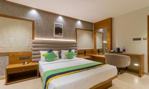 班加罗尔Treebo Trend Tiba的配有一张床和一张书桌的酒店客房