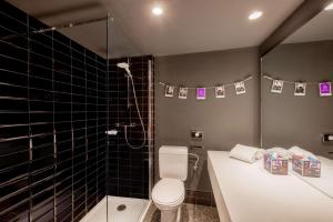 布鲁塞尔nhow Brussels Bloom的浴室设有卫生间和黑色瓷砖淋浴。