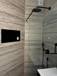 阿姆斯特丹B&B Urban Oasis的带淋浴的浴室,墙上配有电视