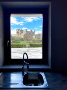 费尼斯À la Bouteucca的厨房水槽设有可欣赏城堡景色的窗户