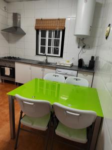 埃尔瓦斯Quinta da Ponte das Hortas 3的厨房配有绿色的桌子和四把椅子