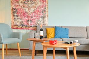 泽伊德拉伦Summio Waterpark De Bloemert的客厅配有一张沙发,桌子上摆放着一瓶葡萄酒