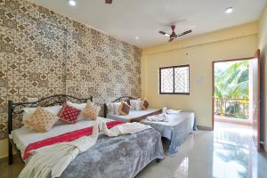 卡兰古特Abbi's Nest Beach House Goa的一间卧室设有两张床和壁纸墙