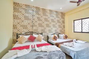 卡兰古特Rooms Beach Bunch House Goa的墙上的房间里设有两张床