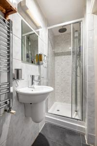 伦敦Gorgeous One Bed in the Heart of Central London的白色的浴室设有水槽和淋浴。