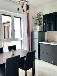 米兰THE WHITE HOUSE, Modern apartment in Center的厨房配有桌椅和冰箱。