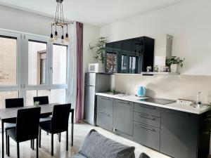 米兰THE WHITE HOUSE, Modern apartment in Center的厨房配有黑色橱柜和桌椅