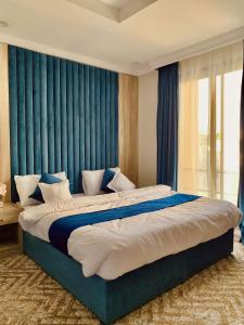 麦加شقق الكوثر الفندقية的一间卧室配有一张带蓝色窗帘的大床