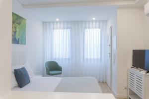 拉梅戈FAFEL LITTLE HOUSE - Quinta de Cravaz的一间白色卧室,配有床和电视
