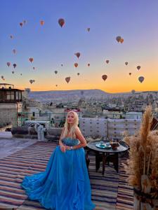 格雷梅泰拉凯芙酒店的穿着蓝色衣服的女子在屋顶上穿着热气球