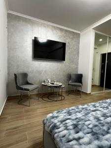RoşuLuxury Studio 7的一间卧室配有一张床、一张桌子和一台电视。