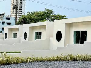 罗勇Sunvada Beach Rayong的白色的建筑,设有圆形窗户