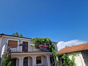 卡潘诺里La casa nella vigna [colline del vino]的白色的房子,阳台上放着鲜花