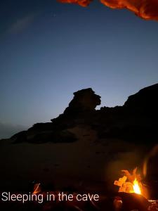 亚喀巴Bedouin experiences的一张火的照片,上面写着睡在洞穴里的单词