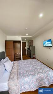 碧瑶Studio Tower by KR的一间卧室设有一张大床和一台墙上的电视。