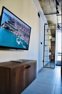 莫斯塔Chic Penthouse industrial-style的客厅的墙上设有大电视