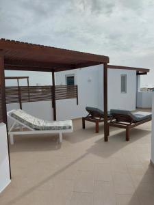 萨尔雷Cala da Lua apartments的屋顶上设有两个长椅和一个凉亭