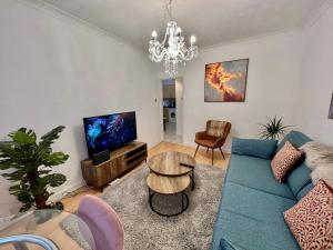 剑桥Central Cambridge Fig Tree House Flat 1的客厅配有蓝色的沙发和电视
