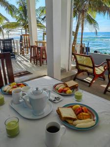 陶尔佩SEASHORE Resort & Villa的一张桌子,早餐包括烤面包和咖啡,还有海洋