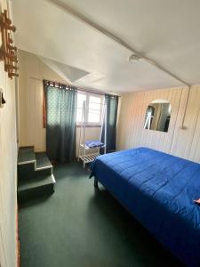 卡斯特鲁La Minga Hostel的一间卧室设有蓝色的床,还有楼梯