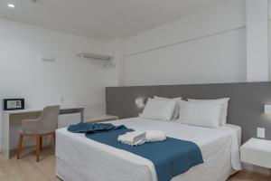 马塞约Hotel Praia Bonita Jangadeiros Pajuçara的一间卧室配有一张带蓝色毯子和椅子的床