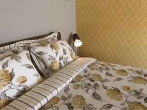 NuthVakantiewoning Hof7tien90的一间卧室配有一张带花卉床罩和灯的床。