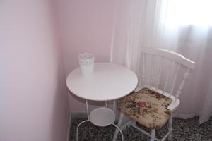 菲格拉斯伊莎贝尔二号旅馆的一张白色的桌子和椅子,上面有一张纸