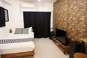 广岛REVISION Kairouyama-tei - Vacation STAY 15801的一间卧室设有一张床和砖墙