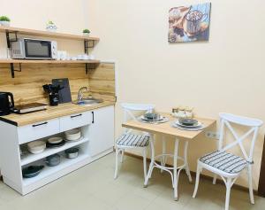 阿拉木图Like Home Rooms的一个带桌子和两把椅子的小厨房