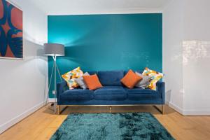海维康Station Apartment High Wycombe的客厅里设有蓝色的沙发,拥有蓝色的墙壁