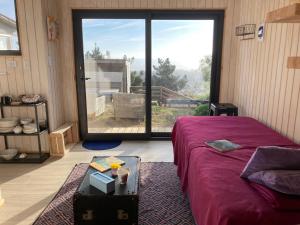 皮奇勒姆Beach escape to Pichilemu - Not so tiny house的一间卧室设有一张床和一个大窗户