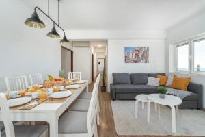 楼尔Spacious & Sunny Flat - Loulé的厨房以及带桌子和沙发的客厅。