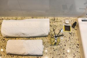 古鲁皮Hotel D'Leon的柜台上备有两条毛巾和时钟