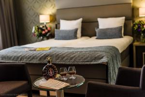 阿姆斯特丹OZO Hotels Arena Amsterdam的酒店客房,配有一张带两杯葡萄酒的床