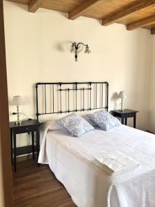 努埃瓦德兰斯La Fragua的卧室配有白色的床和两张桌子
